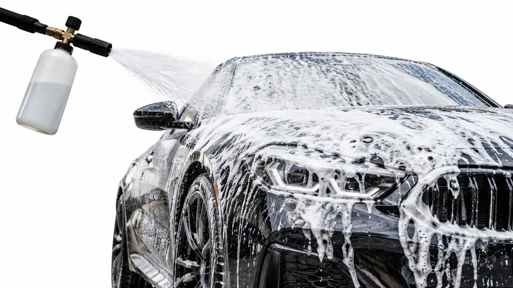 A black luxury sports car being covered in thick cleaning foam using a professional pressure washer sprayer.