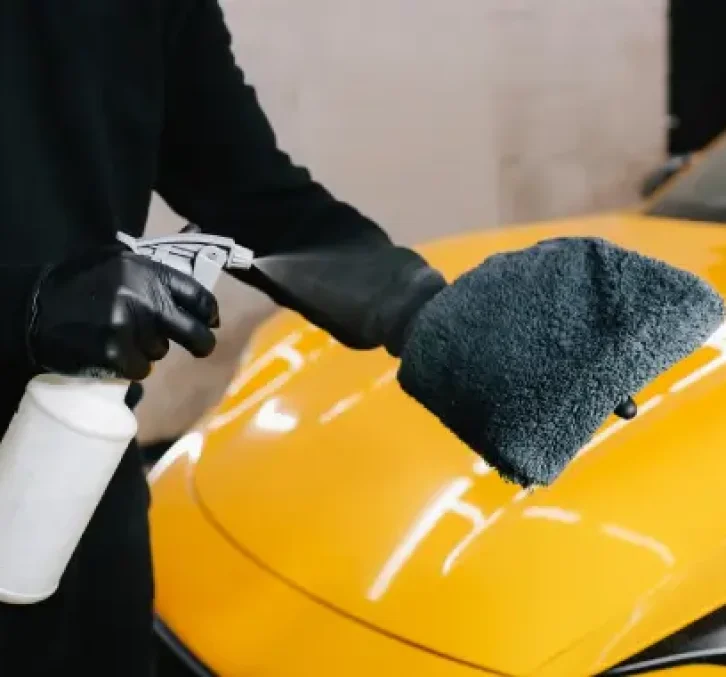 Technician applying quick spray wax for a fast, glossy finish.